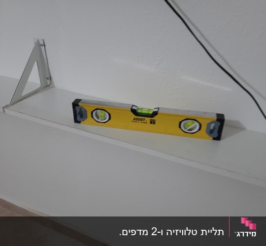 פלס מים צהוב על מדף לבן עם תושבת מתכת